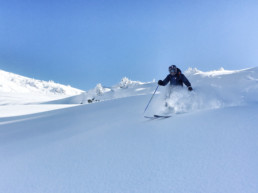 A ski instructor skiing off piste in the powder